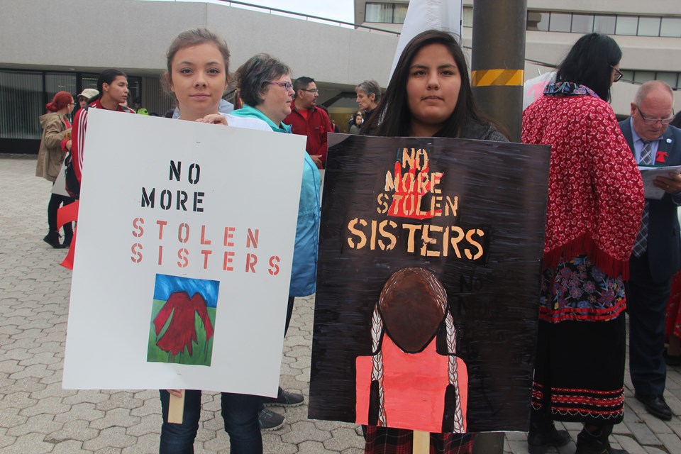 two girls with 'no more' signs